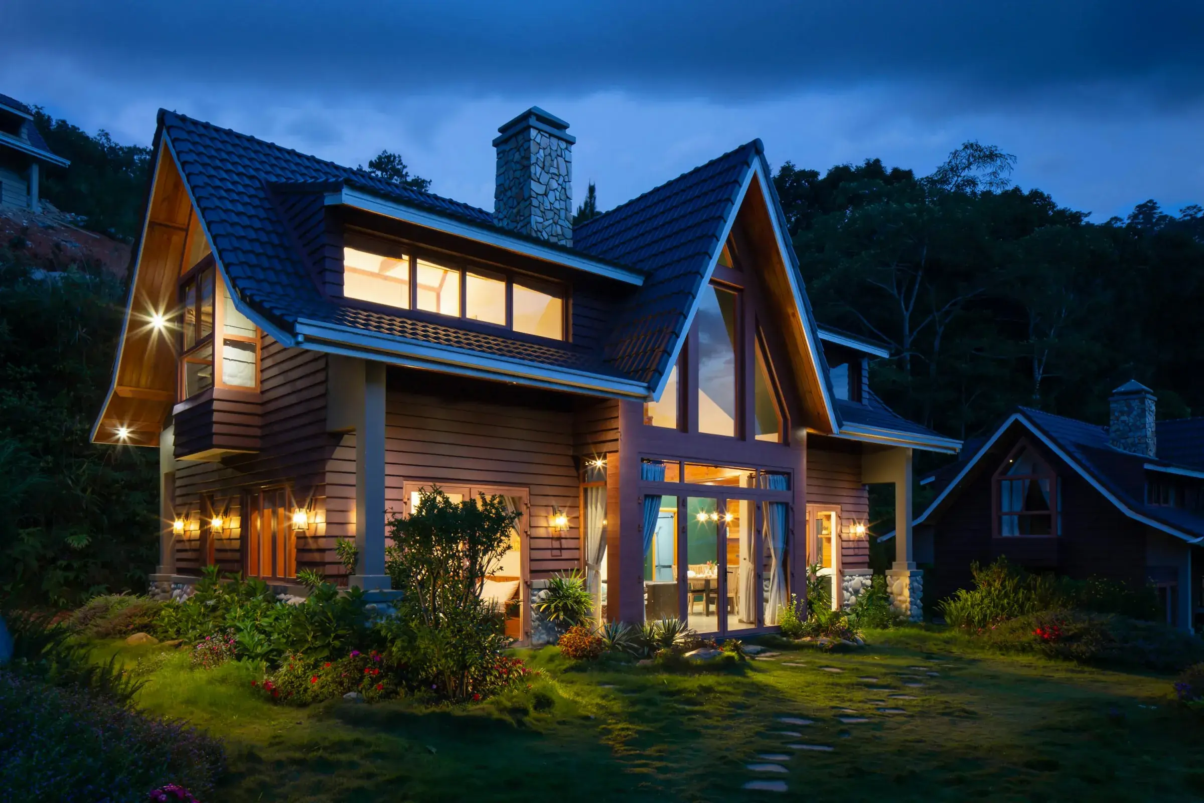 Timber A-frame home lit up at twilight