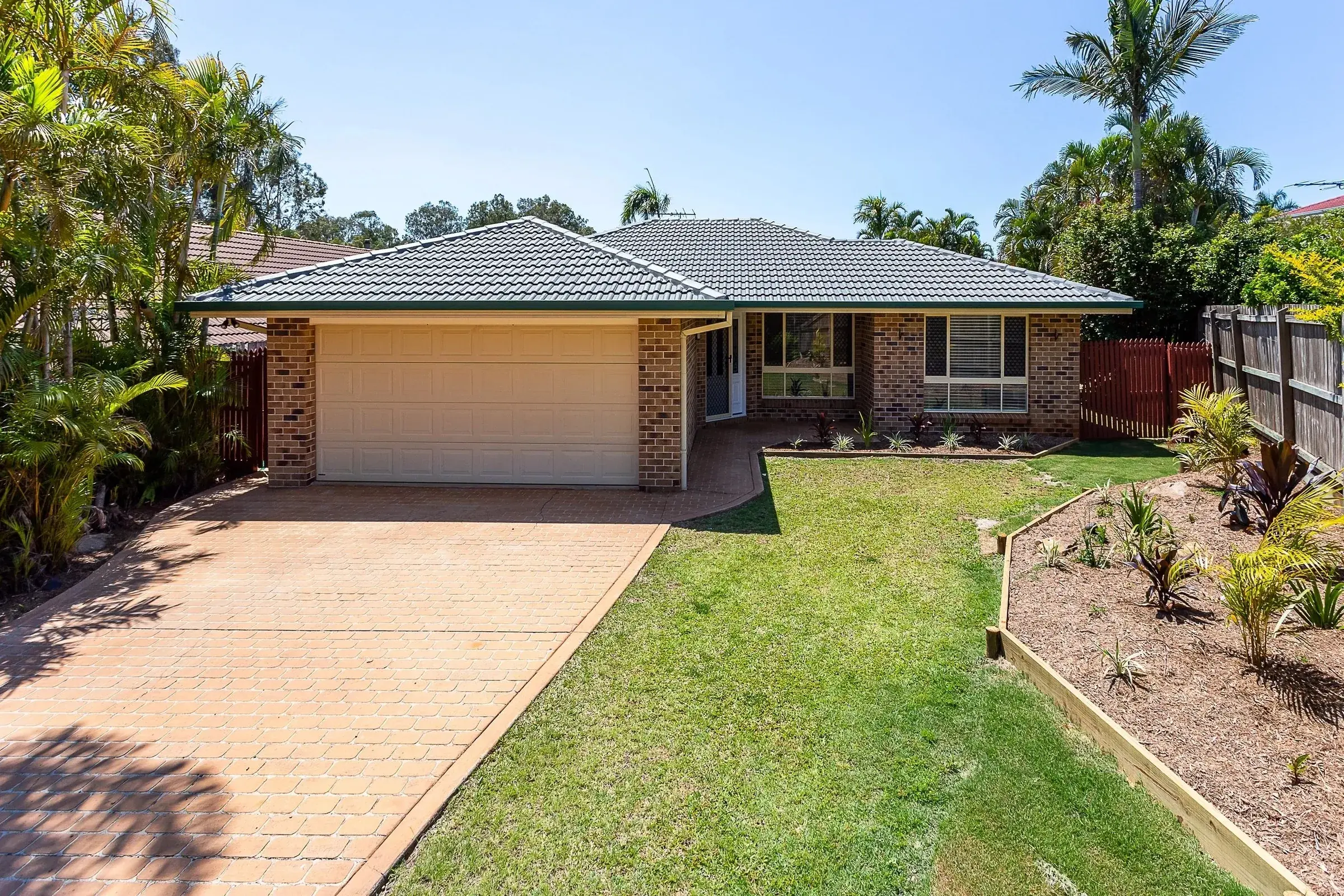 Brick house with a double garage and green lawn